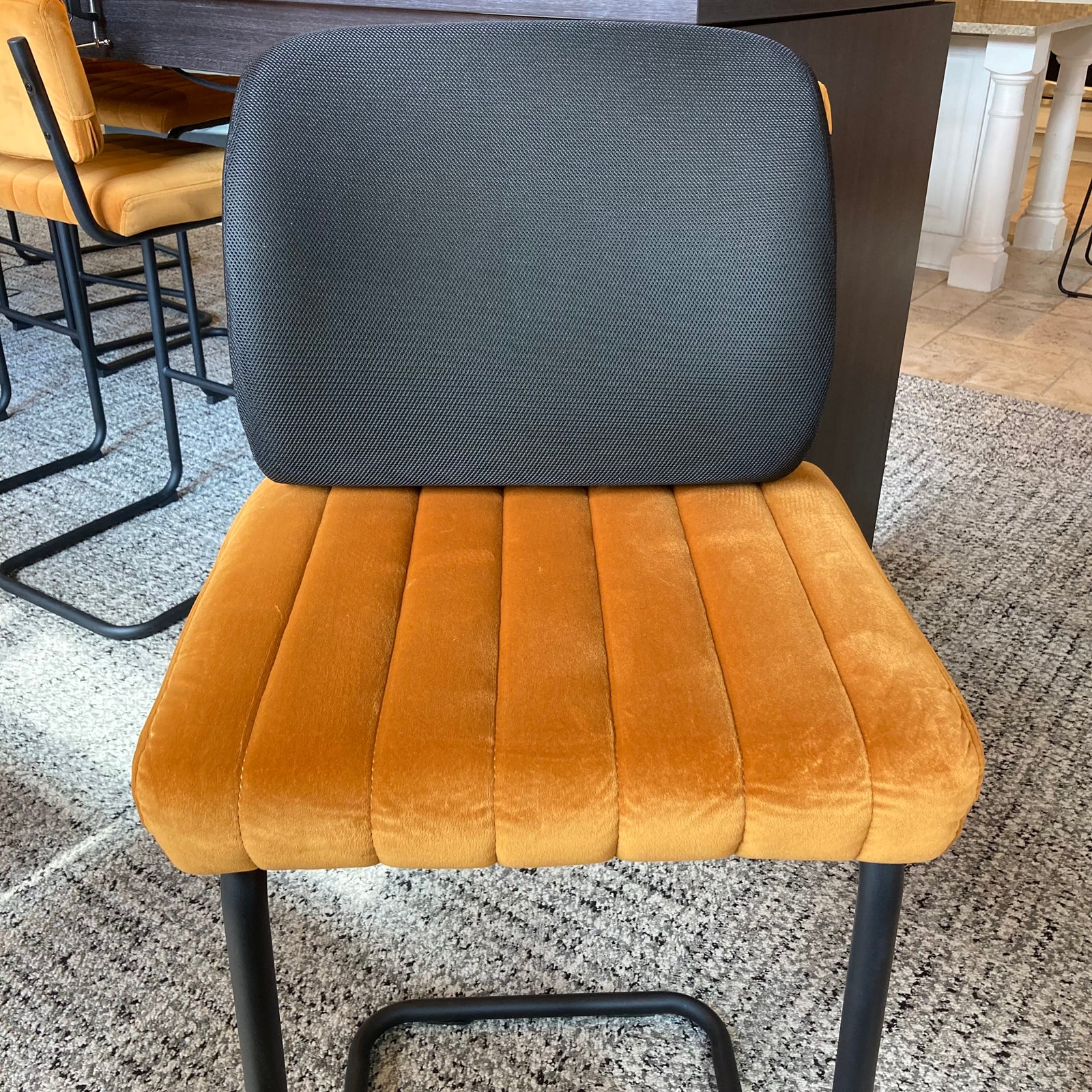 Chair with gray backrest and brown seat on a speckled floor