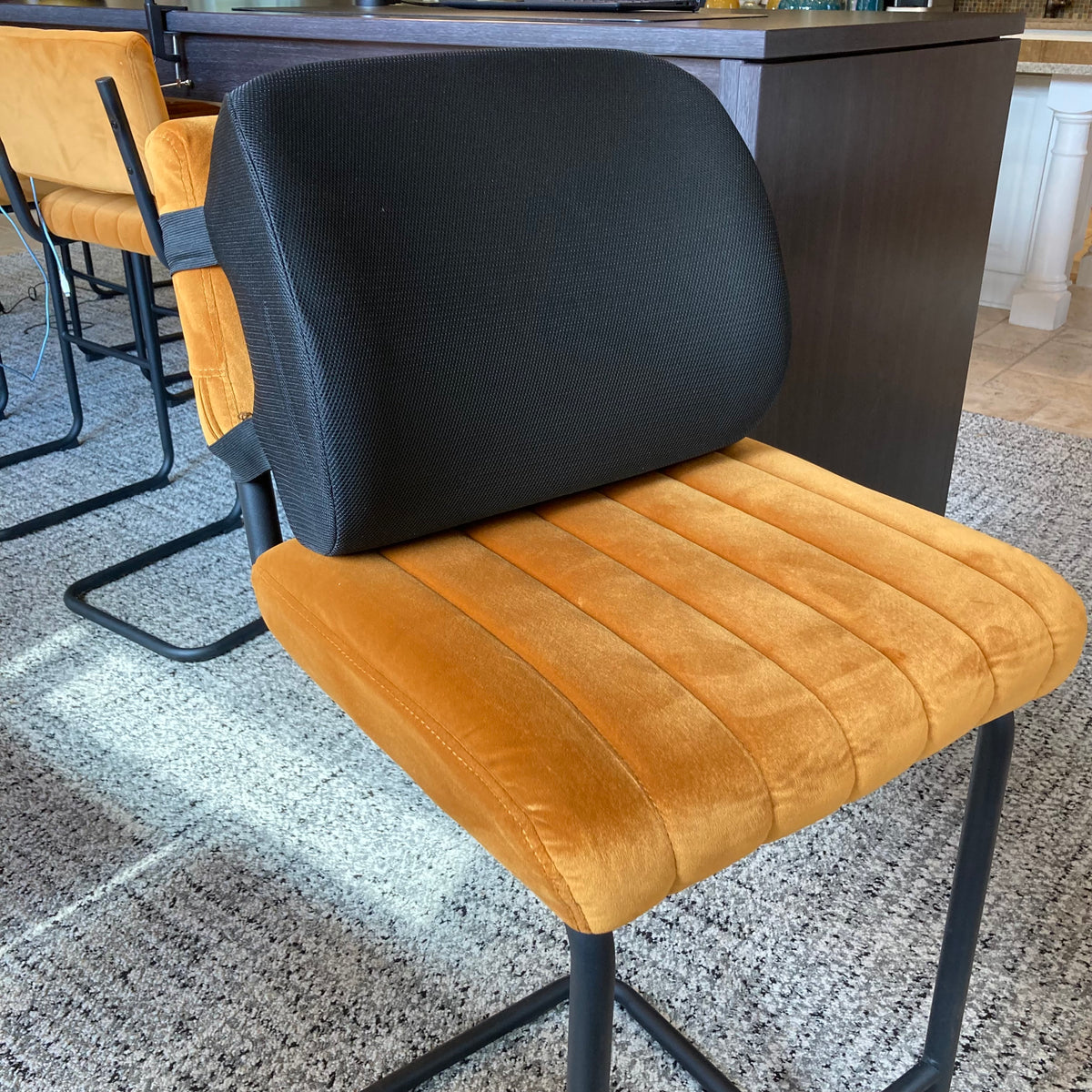 Chair with black backrest and brown seat on a textured floor