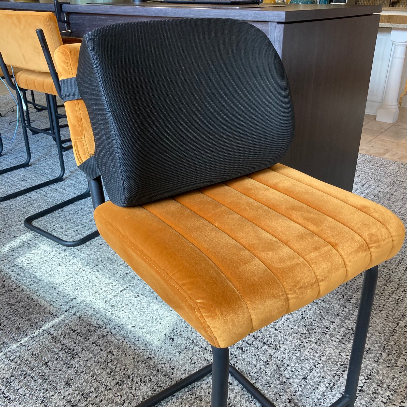Chair with gray backrest and brown seat on a speckled floor