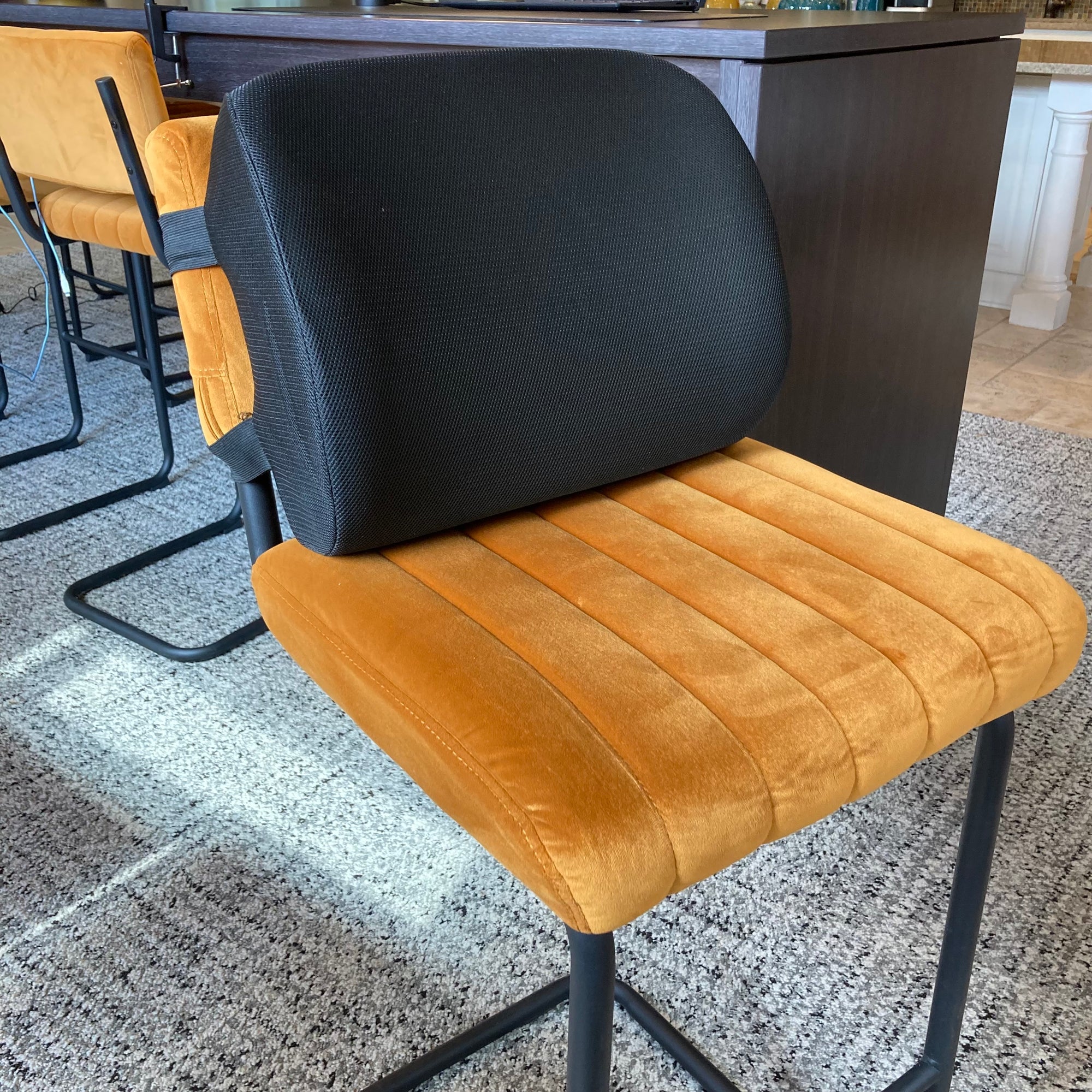 Chair with gray backrest and brown seat on a speckled floor