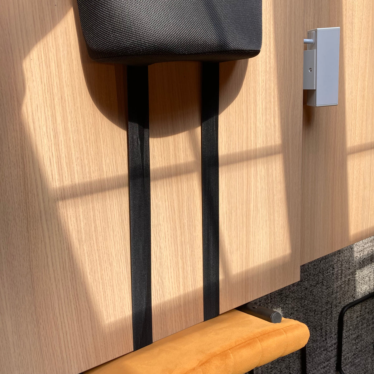 Wooden chair with black legs against a wooden wall